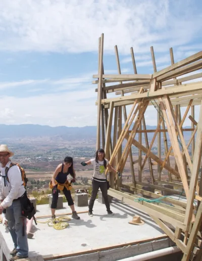 A group of people are building a house on top of a mountain.