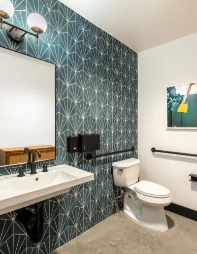 A bathroom with blue wallpaper and a toilet.